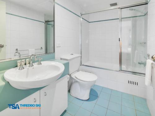 a white bathroom with a sink and a toilet at Snowman 2 in Thredbo
