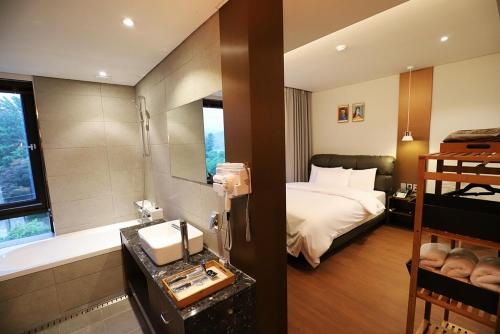 a hotel room with a bed and a bath tub at Namyangju Bukhangang dolcecasa hotel in Namyangju