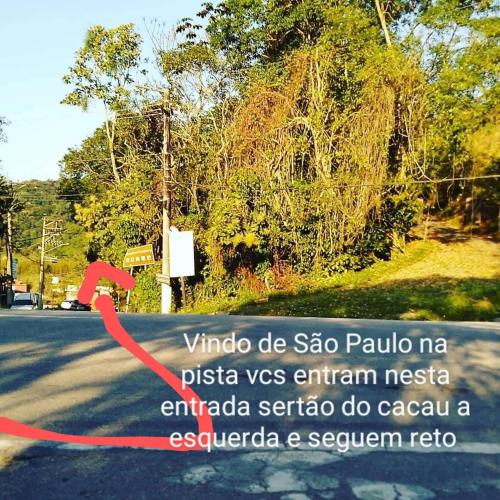 a sign on the side of a road with a red arrow at SUITES E CHALES PRIVADOS Rock's&Rose's home in Camburi