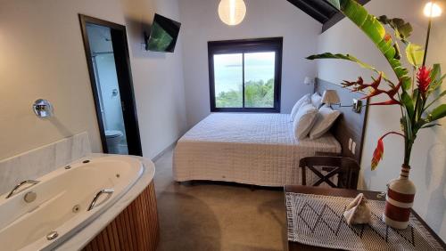 a bathroom with a bed and a tub in a room at Refúgio do Cacupé in Florianópolis