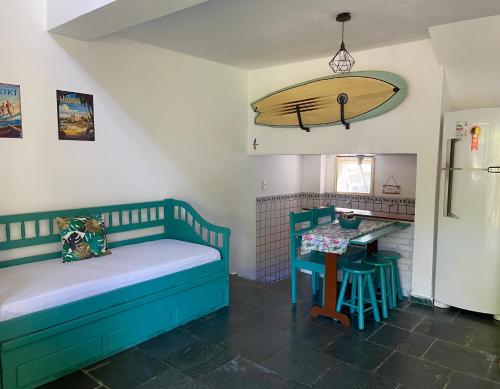 Habitación con cama y mesa con tabla de surf en la pared en Chales da Lua Juquehy, en Juquei