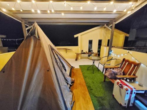 a room with a tent and a table and chairs at Dulan Groundnut Backpacker Hostel in Donghe