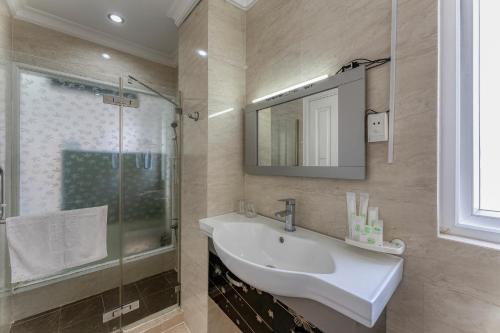 
a bathroom with a tub, sink and mirror at Happy Land Hotel in Ho Chi Minh City
