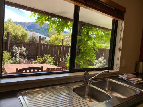 d'un évier de cuisine et d'une fenêtre donnant sur une terrasse. dans l'établissement 3 Mt Isobel Place, à Hanmer Springs