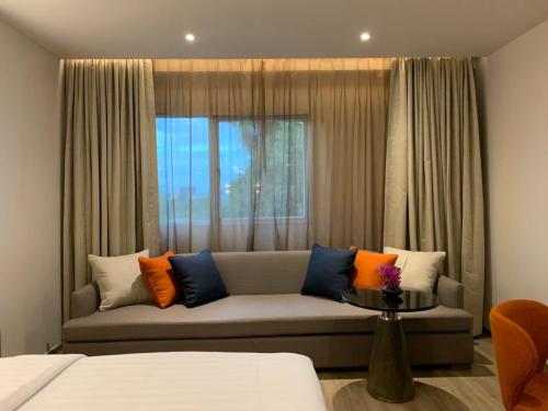 a living room with a couch in front of a window at Sima Thani Hotel in Nakhon Ratchasima