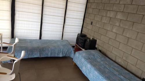 Habitación con 2 camas y TV. en Casa en las sierras, en Villa Parque Síquiman
