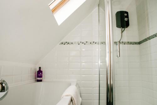 a bathroom with a shower with a sink and a bottle of soap at Holly Cottage, 2 bed house, sleeps 6 in Cleobury Mortimer