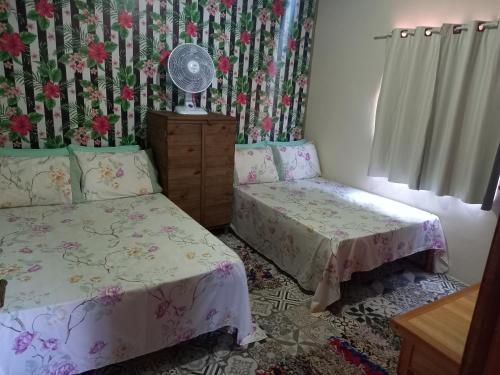 a bedroom with two twin beds and a fan at Chalés Encantos de Cunha Verde in Cunha