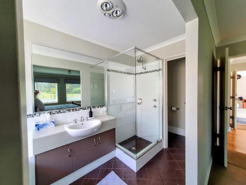 a bathroom with a sink and a glass shower at Hideaway By the Bay in Busselton