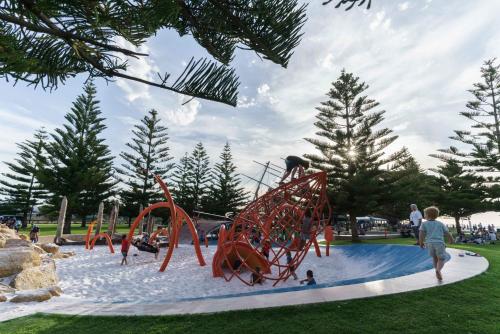 a playground in a park with people playing on it at Hideaway By the Bay in Busselton