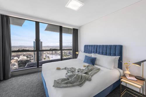 a bedroom with a large bed with a large window at Meriton Suites Herschel Street, Brisbane in Brisbane