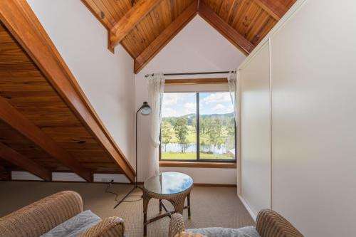 a living room with a large window and a table at Clarendon Forest Retreat in Possum Brush