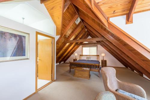 a attic room with a bed and wooden ceilings at Clarendon Forest Retreat in Possum Brush