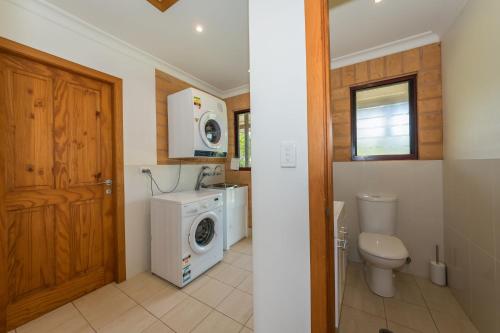a bathroom with a washing machine and a washer and dryer at Clarendon Forest Retreat in Possum Brush