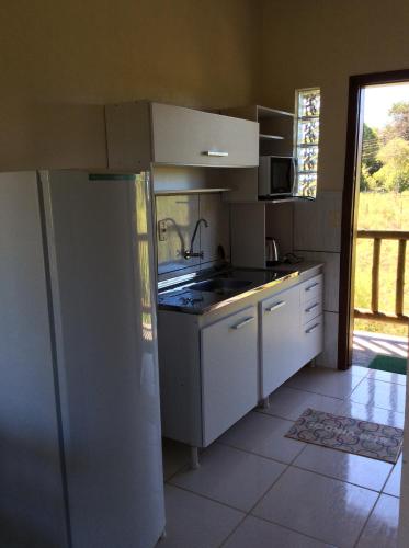 a kitchen with a sink and a stove top oven at Pousada Maori in Praia do Rosa