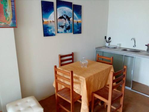 a kitchen with a table with four chairs and a sink at Hospedaje Kaihalulu in Punta Hermosa