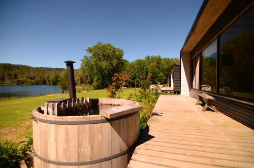 a wooden deck with a bench next to a house at Nativo Lodges in Panguipulli