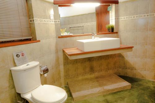 a bathroom with a white toilet and a sink at Gruhaya Boutique Villa in Kandy