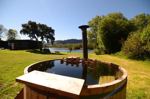 a wooden tub filled with water in a field at Nativo Lodges in Panguipulli