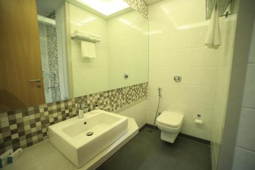 a white bathroom with a sink and a toilet at The Byke Delotel in Mumbai