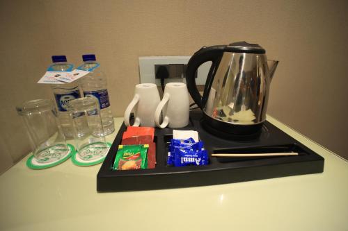 a black tea kettle on a black tray on a counter at The Byke Delotel in Mumbai