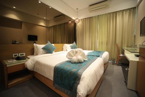 a hotel room with a bed with a towel on it at The Byke Delotel in Mumbai