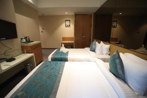 a hotel room with two beds and a bathroom at The Byke Delotel in Mumbai