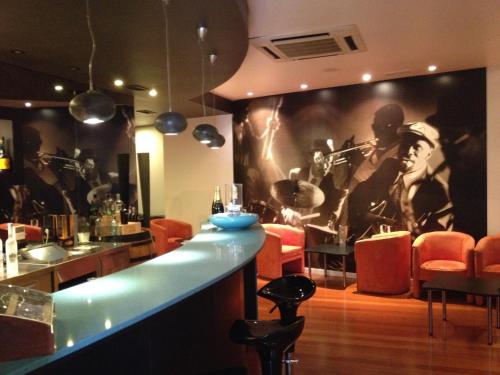 a bar with a painting of a band on the wall at Douro Hotel Porto Antigo in Cinfães