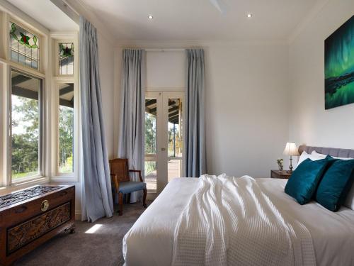 1 dormitorio con 1 cama, 1 silla y ventanas en Loddon Retreat en Glenlyon