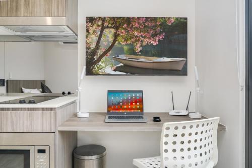 a kitchen with a desk with a laptop computer on it at Coogee Studio Apartments in Sydney