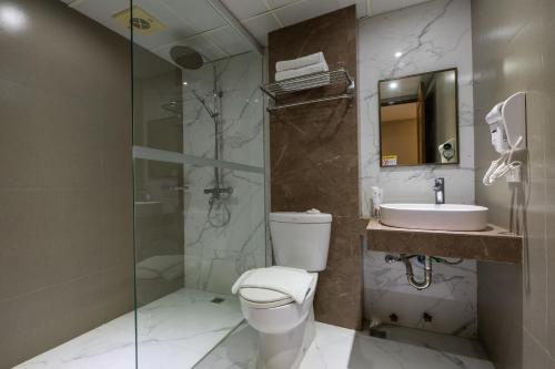 a bathroom with a toilet and a sink and a shower at Star Plaza Hotel in Dagupan