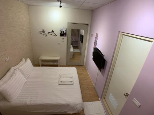 a small bedroom with a white bed and a mirror at Lazy bone in Hsinchu City