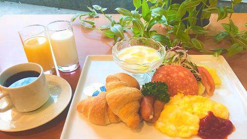 um prato de alimentos de pequeno-almoço numa mesa com uma chávena de café em Hotel Shin Osaka em Osaka