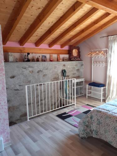 sypialnia z łóżeczkiem dziecięcym w pokoju z drewnianym sufitem w obiekcie Baita Melissa w mieście Vercana