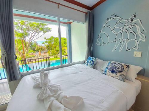 a bedroom with a large white bed with a window at Seattle Samaesarn Resort in Ban Samae San