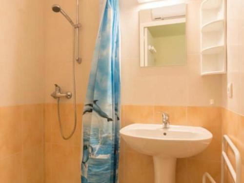 y baño con lavabo y ducha con cortina de ducha. en Gîte Piriac-sur-Mer, 3 pièces, 4 personnes - FR-1-306-857, en Piriac-sur-Mer
