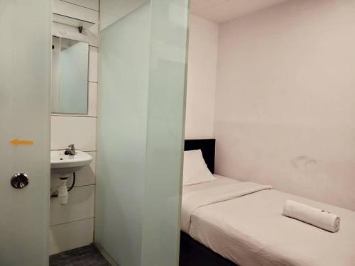 a small bathroom with a bed and a sink at 7 Hotel in Juru