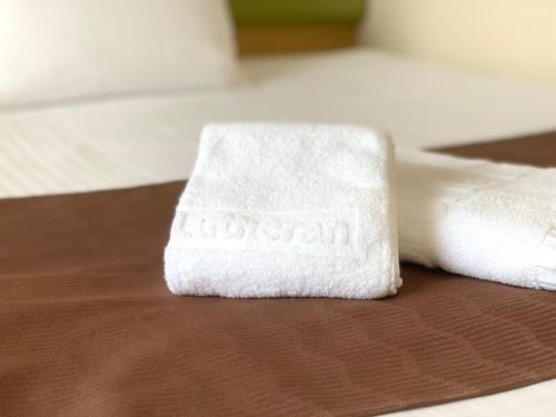 two white towels sitting on top of a bed at Hotel the Lutheran in Osaka