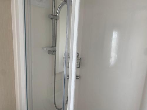 a shower in a bathroom with a glass door at Paul’s place silversands in Lossiemouth