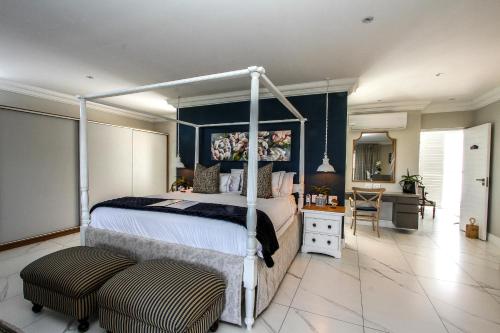 a bedroom with a canopy bed and a desk at Sandals Guest House in Durban