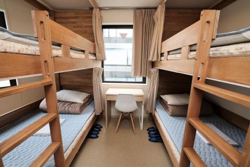 a dorm room with bunk beds and a desk at Tokyo Ueno Youth Hostel in Tokyo