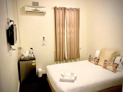 ein kleines Zimmer mit einem Bett mit Handtüchern darauf in der Unterkunft Windsor Hotel Miles in Miles