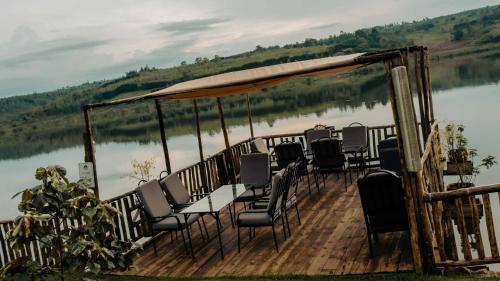 a table and chairs on a deck next to a lake at Vintage Cottage in Rwamagana