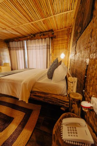a bedroom with a bed and a telephone in a room at Vintage Cottage in Rwamagana