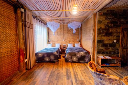 a room with two beds and a table and chairs at Vintage Cottage in Rwamagana