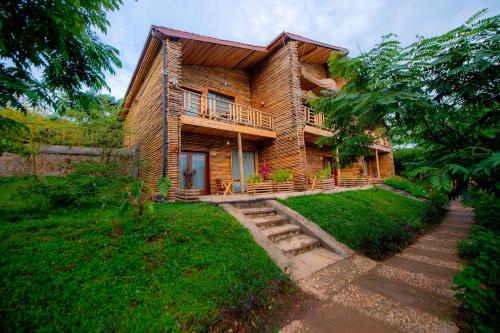 a wooden house with a porch and a balcony at Vintage Cottage in Rwamagana