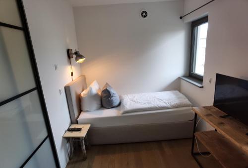 a small room with a bed and a window at City Suites Murnau in Murnau am Staffelsee