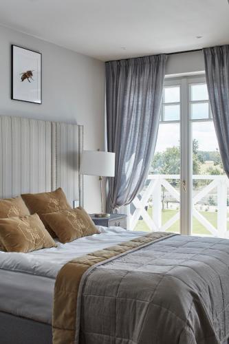 a bedroom with a bed and a large window at Farma Bii in Brzeziny