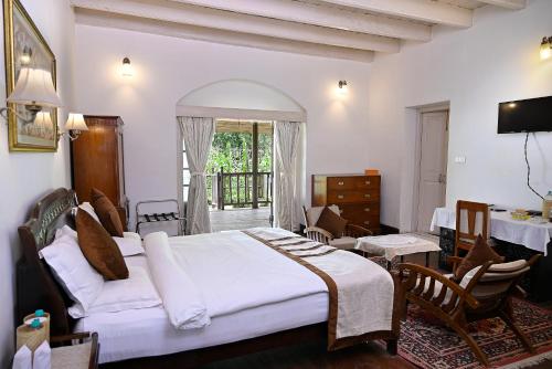 ein Schlafzimmer mit einem großen weißen Bett in einem Zimmer in der Unterkunft Tumsong Tea Retreat in Darjeeling