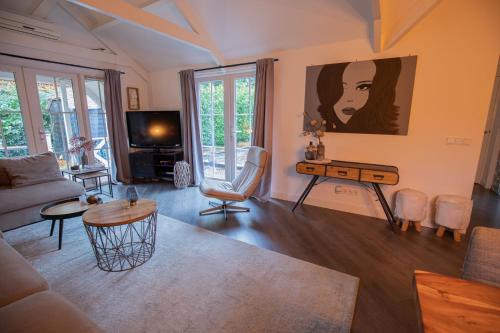 een woonkamer met een bank en een tafel bij Luxe chalet Beekbergen nl in Beekbergen
